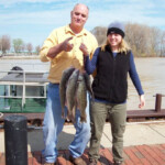 man and woman holding their fish