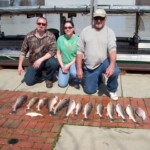 3 charter guests with their fish catch